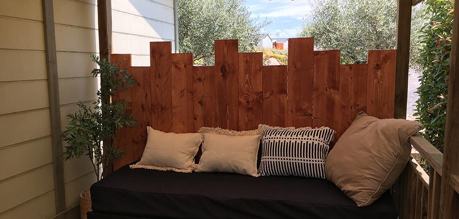 La terrasse couverte avec banquette du chalet Premium, en location au camping les Amandiers à Castelnau de Guers