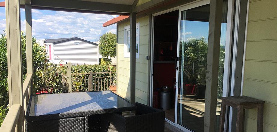 The covered terrace with garden furniture of the Premium chalet, for rent at Les Amandiers campsite in the Hérault