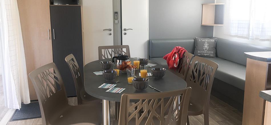 Sala de estar con sofá del mobil home Cottae de 3 habitaciónes en alquiler en el camping les Amandiers en Castelnau de Guers