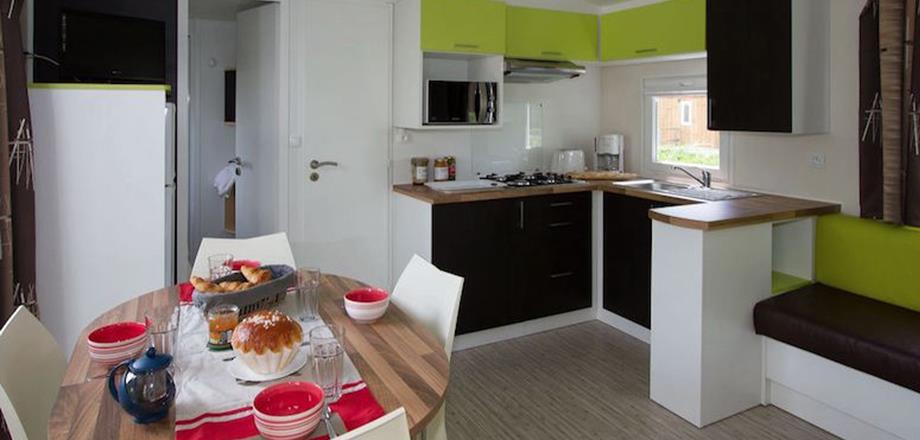 The kitchen and dining area of the 4 persons mobile home Cottage, for rent at camping Les Amandiers near Pézenas