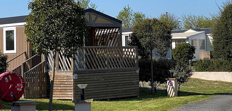 Uitzicht op het halfoverdekte terras van de mobile home Loggia Bay, te huur op camping Les Amandiers bij Pézenas