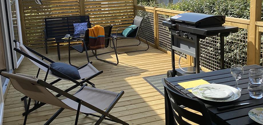 The half covered terrace with gas plancha, garden furniture and deckchairs of the mobile home Premium Garden side 2