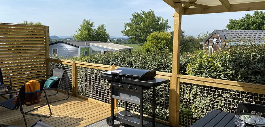 La terrasse du mobil-home Premium côté jardin 4 personnes équipée d’une plancha au gaz, en location au camping les Amandiers