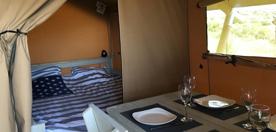 Sala de estar y habitación con 1 cama doble en la tienda Safari, en alquiler un alojamiento insólito en el camping Les Amandiers cerca de Pézenas