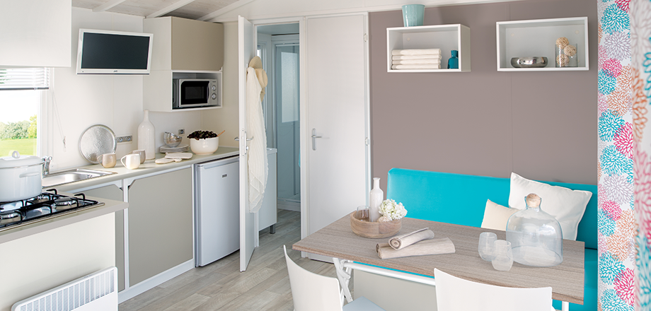 The kitchen and dining area of the 4 persons Loggia mobile home, for rent at the Les Amandiers campsite in Castelnau de Guers.