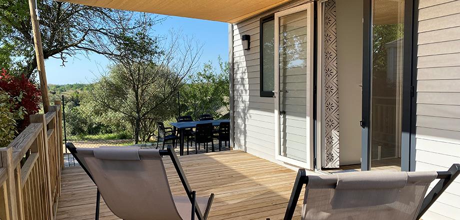 Overdekt terras met tuinmeubilair en ligstoelen in de stacaravan Family, te huur op camping Les Amandiers in de Hérault in Frankrijk