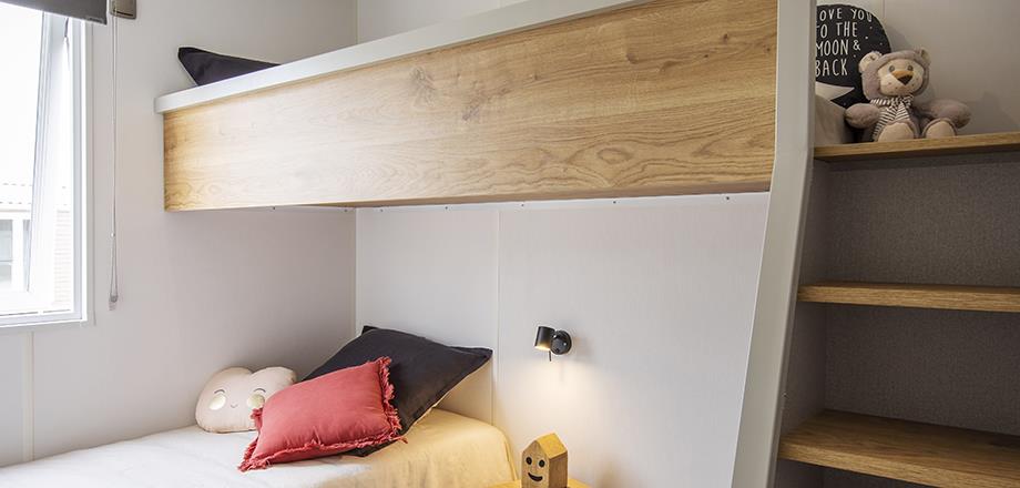Chambre avec store occultant et moustiquaire du mobil-home Family en location au camping les Amandiers dans l’Hérault