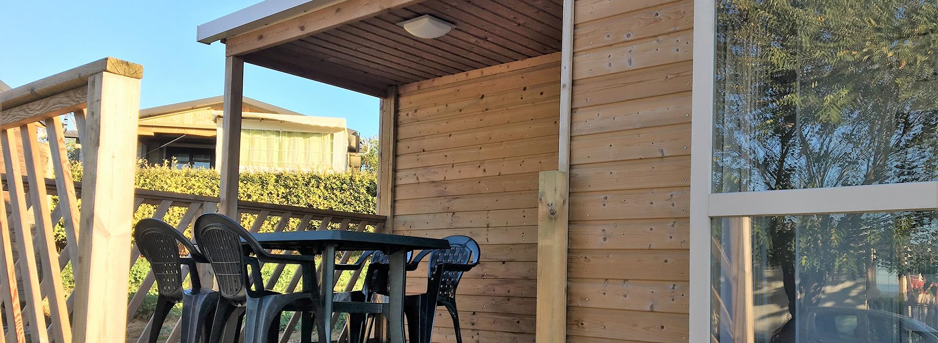 Halfoverdekt terras met tuinmeubilair in de 4-persoons mobile home Loggia, te huur op camping Les Amandiers