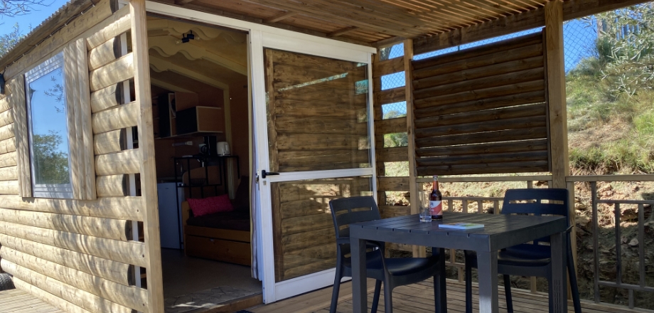 Terrasse couverte de la roulotte Arizona, en location hébergement insolite au camping les Amandiers